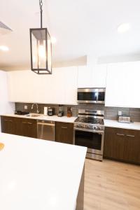 a kitchen with white cabinets and a stove top oven at Stylish luxe apartment close to New york city in Union City