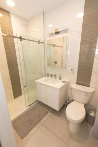 a white bathroom with a toilet and a shower at Stylish luxe apartment close to New york city in Union City