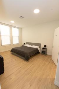 a bedroom with a bed and a wooden floor at Stylish luxe apartment close to New york city in Union City