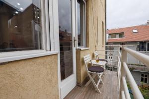 a balcony with two chairs and a window at Apartment Stay in Novi Sad
