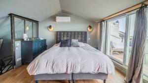 ein Schlafzimmer mit einem Bett und einem großen Fenster in der Unterkunft A CASA DIVINA au coeur de la Citadelle in Bastia