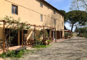a building with tables and plants in front of it at La Tonnaia in Lari