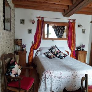 a bedroom with a bed and a window at la glycine in Asnelles