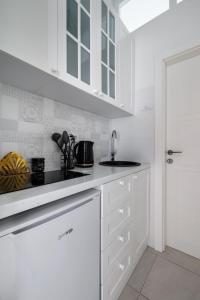 uma cozinha branca com armários brancos e um lavatório em Apartment Stay em Novi Sad