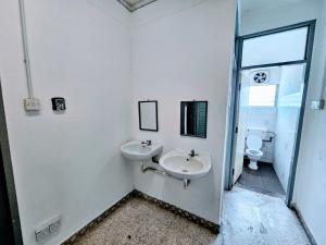 bagno bianco con lavandino e servizi igienici di PANCHOR 6 HOSTEL a George Town