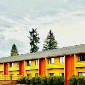un bâtiment jaune et rouge avec des arbres en arrière-plan dans l'établissement Cozy Inn, à Centralia