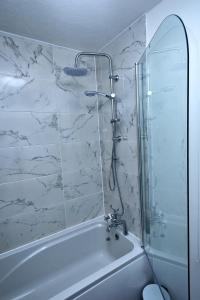 a bathroom with a shower and a bath tub at I Love London! A Stunning 2 Bed Home Sleeps 1-3! in London