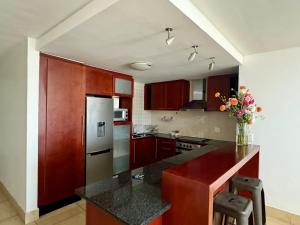 a kitchen with red cabinets and a black counter top at Loddey's Self Catering Apartments - by Beach Collection in Strand