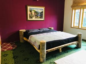 a bed in a room with a painting on the wall at Hunza Verse in Hunza