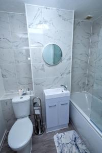 a bathroom with a toilet and a sink and a mirror at I Love London! A Stunning 2 Bed Home Sleeps 1-3! in London