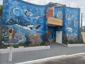 un edificio con un mural en el costado en Pousada Sol e Lua en Caraguatatuba