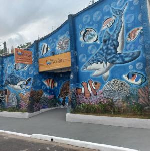 un muro con un murale di balene e pesci di Pousada Sol e Lua a Caraguatatuba