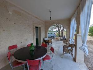 une salle à manger avec une table noire et des chaises rouges dans l'établissement 3 bedroom country villa with 2 large verandas, à Torre Ovo