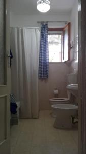 La salle de bains est pourvue d'un lavabo, de toilettes et d'une fenêtre. dans l'établissement 3 bedroom country villa with 2 large verandas, à Torre Ovo