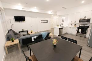 ein Wohnzimmer mit einem Tisch und einer Küche in der Unterkunft Mins to NYC - Lavish modern 2-bed apartment in Bayonne