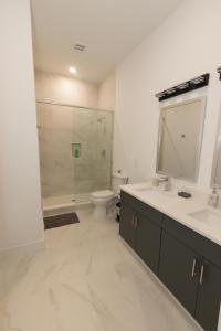 a bathroom with a toilet and a sink and a mirror at Mins to NYC - Lavish modern 2-bed apartment in Bayonne