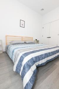 ein Schlafzimmer mit einem Bett mit einer blauen und weißen Decke in der Unterkunft Mins to NYC - Lavish modern 2-bed apartment in Bayonne