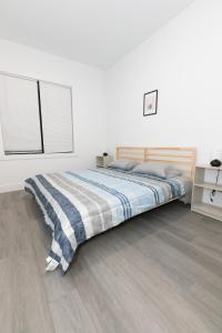 a bedroom with a bed with a blue and white blanket at Mins to NYC - Lavish modern 2-bed apartment in Bayonne