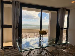 ストランドにあるLoddey's Self Catering Apartmentsのビーチの景色を望むダイニングルーム(ガラス張りのテーブル付)