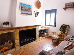 a living room with a fireplace and a couch at Cortijo El Pilón in Vélez Blanco