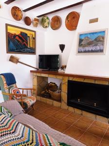 a living room with a fireplace and a tv at Cortijo El Pilón in Vélez Blanco +54 photos