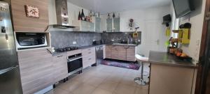a kitchen with stainless steel appliances and a counter at Chambre à louer. Jo Vaires-sur-Marne in Vaires-sur-Marne