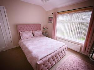a bedroom with a pink bed and a window at Entire 3-Bedroom Home in Oldham - Guest house in Oldham