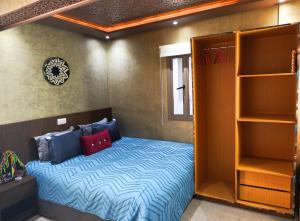 a small bedroom with a bed and shelves at Good Vibes in Rabat