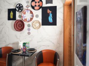 una sala da pranzo con 2 sedie arancioni e un tavolo di Good Vibes a Rabat