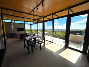 a room with a table and chairs and windows at Villa Toscana II - Excelentes Vistas y Confort in Villa Serrana