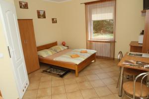a bedroom with a bed and a table and a window at Lorens Family in Mikołajki