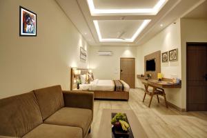 a living room with a couch and a bed at Hotel Claytone Near Delhi Airport in New Delhi