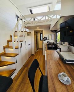 eine Küche und ein Wohnzimmer mit einer Treppe in einem winzigen Haus in der Unterkunft Natural Garden Tiny House Yalikavak in Yalıkavak