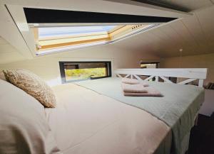 sypialnia z dużym białym łóżkiem i świetlikiem w obiekcie Natural Garden Tiny House Yalikavak w mieście Yalıkavak