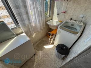 uma pequena casa de banho com WC e lavatório em Guaruja Conforto e Lazer - Apartamento na Praia da Enseada no Guarujá