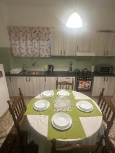 a kitchen with a table with a green table cloth at Alex Apartment in Athens