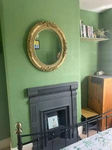 a room with a fireplace and a mirror on the wall at Seaside Villa on Secluded Green in Kent