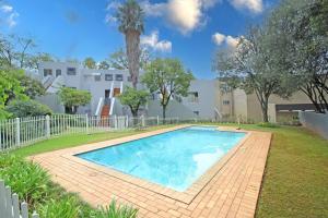 een zwembad in de tuin van een huis bij Madison Palms apartment in Sandown in Johannesburg