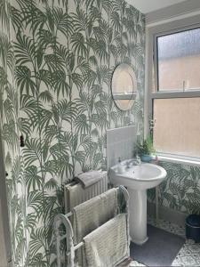 uma casa de banho com um lavatório, um WC e um espelho. em Seaside Villa on Secluded Green em Kent
