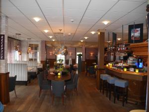 a restaurant with a table and chairs and a bar at Het Wapen van Enkhuizen in Enkhuizen