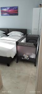 a bedroom with two beds and a crib in it at Umbrella Apartment in Perea