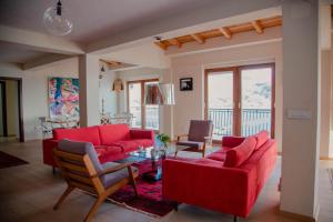 a living room with red couches and a table at Villa Norvegia in Ohrid