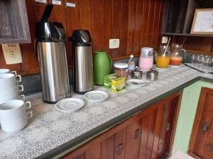 Pousada Sol e Lua في كاراغواتاتوبا: أعلى المنضدة مع وعاء القهوة وآلة صنع القهوة