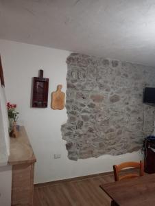 Una pared con una pared de piedra con un reloj. en CASA DEL CORSO, en Dorgali