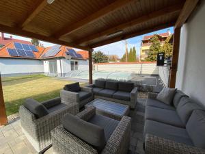 a patio with couches and a grill with solar panels at Ady13 Vendégház Eger in Eger