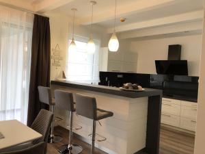 a kitchen with a bar with chairs and a table at Ady13 Vendégház Eger in Eger
