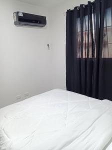 a bedroom with a white bed with a window at Cómodo y acogedor apartamento in Mendoza