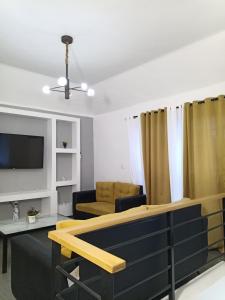 ein Wohnzimmer mit einem Sofa und einem TV in der Unterkunft Cómodo y acogedor apartamento in Mendoza