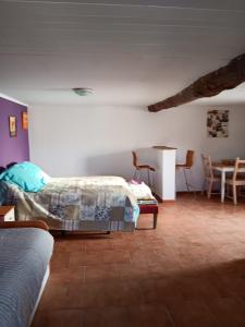 1 dormitorio con 1 cama, mesa y sillas en QUINTA FENIX - Studio familial avec cuisine, en Cerejeiras