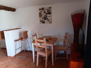 ein Esszimmer mit einem Holztisch und Stühlen in der Unterkunft QUINTA FENIX - Studio familial avec cuisine in Cerejeiras